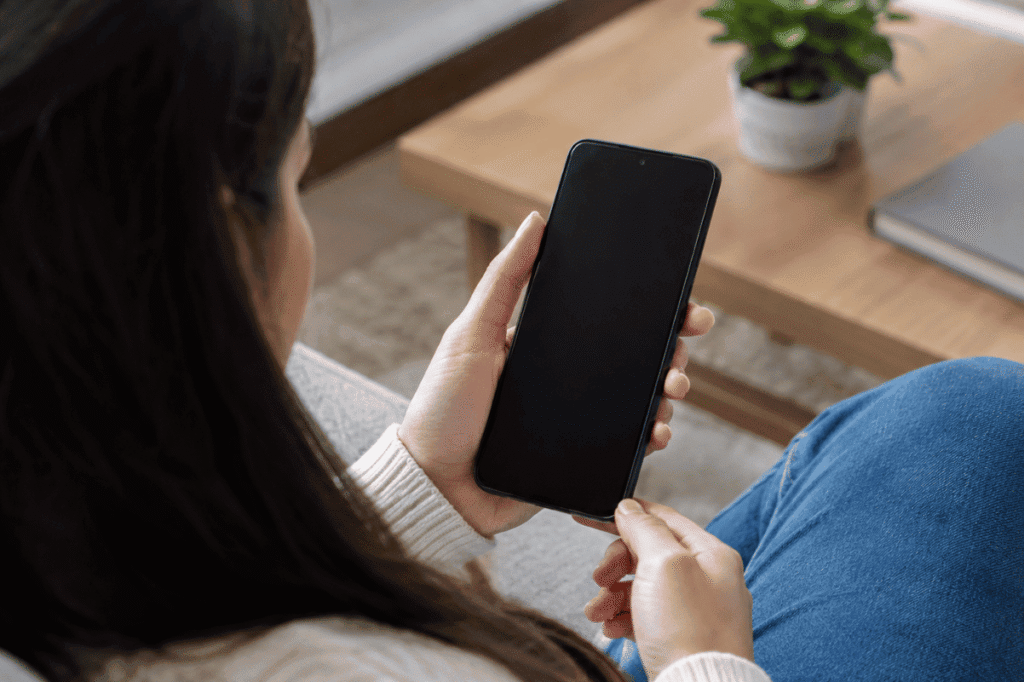 person holding Android phone black screen